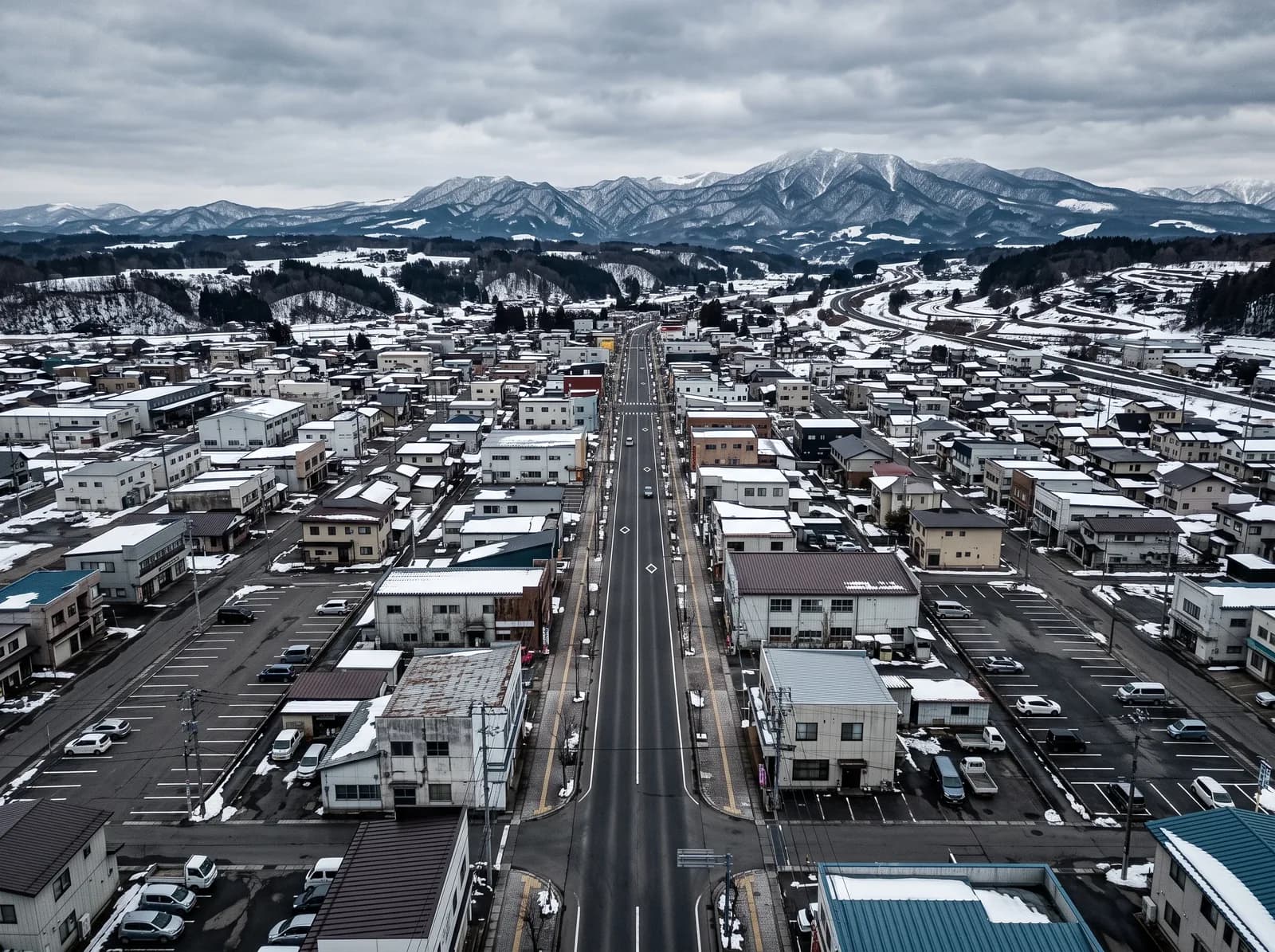 拠点を置く岩手県北上市の市街地。中心を貫く大通りと、その先に連なる雪をかぶった山並み